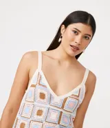 Vestido corto de punto con técnica de ganchillo, diseño de cuadros multicolores en tonos pastel y marrón, tirantes finos y escote en V.