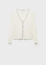 Cardigan de punto canalé color blanco, con cuello en V y cierre frontal de botones. Presenta un diseño ajustado con ribetes en contraste negro en el cuello y la botonera.
