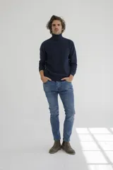 Sweater de cuello alto en color tostado, confeccionado en tejido de punto con textura en el panel frontal y mangas lisas. Presenta puños y ruedo acanalados.