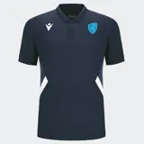 Polo de rugby azul marino con cuello y tapeta de botones en azul oscuro sólido. El cuerpo de la prenda presenta un patrón geométrico sutil en relieve. Tiene paneles laterales en color blanco que se extienden desde la axila hasta el bajo. Incluye el logo Macron en blanco y un escudo bordado en color celeste con la figura de un ave.