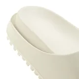 Sandalias Adidas modelo Campus 00S Foam Slide, color blanco, con diseño deslizante de una sola tira con el logo en relieve y suela dentada.