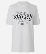 Remera blanca de algodón con cuello redondo y mangas cortas. Estampa trasera con la frase "Challenge Yourself", una pelota de baloncesto y estrellas.