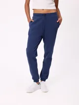 Pantalón tipo babucha de algodón y poliéster, con cintura elástica ajustable mediante cordón, bolsillos laterales y puños elásticos en los tobillos. Presenta un pequeño logo bordado en la pierna izquierda.