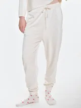 Pantalón de dormir confeccionado en plush acanalado de tacto suave. Presenta un diseño holgado con cintura elastizada y cordón ajustable, bolsillos laterales y puños elastizados en los tobillos.