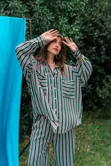 Camisa de fibrana con diseño de rayas verticales rojas y blancas, corte oversize, mangas largas abullonadas, cuello camisero y bolsillos frontales con solapa.