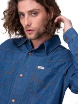 Camisa de denim azul de manga larga con diseño western, canesú frontal, bolsillos en el pecho con costuras decorativas y botones metálicos a presión.