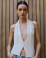 Top tejido color crudo con escote halter pronunciado y espalda descubierta.