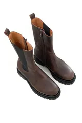 Bota de cuero color marrón chocolate, con elásticos laterales negros, cierre lateral y suela track color negro.