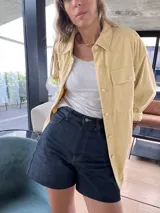 Sobrecamisa de pana color amarillo, con cuello clásico, cierre frontal de botones y bolsillos delanteros con solapa.