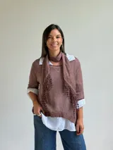 Sweater de punto color marrón chocolate con cuello redondo, mangas tres cuartos y diseño asimétrico. Incluye un pañuelo a juego con detalles de puntilla en los bordes.