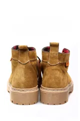Bota acordonada de cuero gamuza color beige, con suela de goma dentada y forro interior a cuadros.