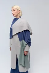 Ruana tejida de punto con bloques de color beige y marrón. Confeccionada en lambswool.