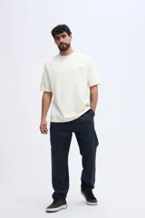 Remera de manga corta color beige con textura sutil y estampa discreta en el pecho.