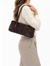 Cartera de cuero tipo baguette, con formato alargado, acabado de efecto vintage, dos asas largas para llevar al hombro y cierre superior.