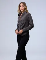 Camisa azul en símil suede, marca Ninety. Cuello con solapa y abertura central con botones. Delantera fruncida.