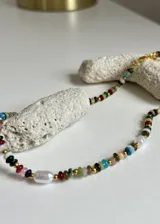 Collar corto con cuentas de vidrio de colores y perlas de río, con detalles en acero dorado.