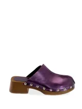 Zueco tipo mule de cuero color morado metálico, con plataforma y tacón de madera. Presenta detalles de tachuelas plateadas alrededor de la base.