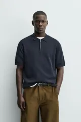 Polo de punto de algodón con corte regular, cuello solapa y cierre frontal de cremallera. Presenta manga corta y acabados en rib.