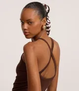 Body marrón oscuro de tejido acanalado, con escote redondo y breteles finos que se cruzan en la espalda.