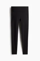 Leggings deportivas de talle alto en color negro, confeccionadas en tejido funcional SoftMove con tecnología DryMove. Presentan cintura ancha y bolsillos abiertos laterales en cada pierna.