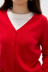 Cardigan de punto color natural, con escote en V profundo, cierre frontal con botones y mangas largas.