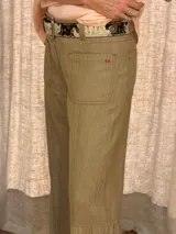 Jean de denim azul con bolsillos delanteros aplicados, costuras verticales y diseño de tablas en los laterales de las piernas amplias.