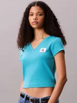 Remera de Calvin Klein confeccionada en punto de algodón elástico con textura de canalé fino. Presenta un diseño de corte slim, cuello en V, manga corta y una insignia con el logo de la marca en el pecho.