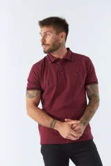 Polo gris de piqué de algodón, corte regular, manga corta con ribete azul marino, cuello clásico con botones y logo bordado en el pecho.