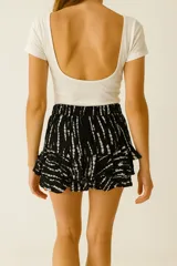 Short de tiro alto confeccionado en viscosa, con diseño evasé, detalle de volados en el ruedo y lazo ajustable en la cintura.