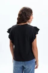 Remera de manga corta color negro, con cuello redondo y detalle de volados en las mangas confeccionados en broderie.