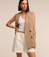 Short de vestir color beige, con cintura alta, pliegues frontales, cinturón de cuero sintético con hebilla metálica y cierre frontal con botón y cremallera.