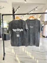 Remera oversize de efecto gastado color celeste, con cuello redondo y mangas cortas. Estampado frontal pequeño con el texto "Top Style" y gran estampado en la espalda con el mismo texto, la frase "Dream big. Work hard. Make it real.", el año "SINCE 2021" y un código de barras.