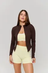 Campera deportiva de ajuste entallado, color marrón, con cuello alto, cierre frontal completo y mangas largas con aberturas para pulgares.
