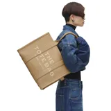 Bolso tipo tote de gran tamaño, confeccionado en cuero premium color tostado. Presenta el logo distintivo de la marca estampado en el frente y doble asa superior para llevar al hombro.