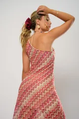 Vestido midi de crochet con diseño de ondas en tonos rojo, rosa y beige. Tiene un solo hombro y tajos laterales.