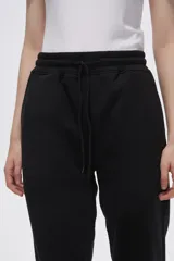 Pantalón tipo babucha de corte recto, confeccionado en tejido con felpa, con cintura elástica y cordón de ajuste frontal.