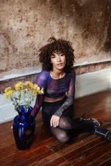 Top corto de tul estampado con diseño abstracto en tonos azul, rojo y negro, de mangas largas y corte ajustado.