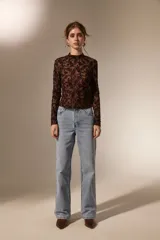 Top de manga larga con cuello alto, confeccionado en tejido semitransparente con estampado tipo paisley en relieve.