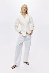 Blazer de mujer confeccionado en tejido efecto neopreno, en color blanco. Cuenta con cuello en V profundo, sin solapas, cierre frontal con broche a presión oculto, hombros caídos, mangas largas y bolsillos laterales de ojal simulados.