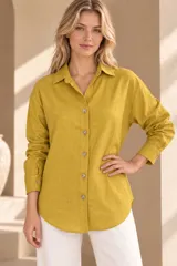 Camisa de lino color mostaza, de corte clásico con cuello camisero, manga larga y cierre frontal abotonado.