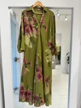 Vestido midi verde pistacho con estampado floral rosado, escote en V con cuello camisero, cierre frontal con botones y mangas tres cuartos.