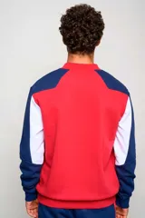 Buzo deportivo Umbro del Club Nacional de Football, color rojo con mangas azul marino y detalles blancos. Cuenta con cuello redondo y el logo de la marca y del club bordados en el pecho.
