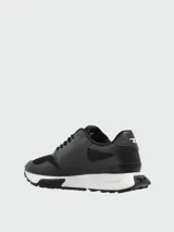Zapatillas deportivas Diesel modelo S-Tame-D, color negro con detalles en blanco, confeccionadas en una combinación de cuero sintético y malla, con suela dentada y el logo de la marca en el lateral.
