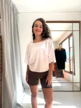 Remera blanca de algodón con escote barco y mangas cortas amplias. Presenta un detalle de torzado en la espalda.