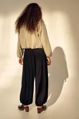 Pantalón globo negro de punto de crepé, con corte relajado, cintura elástica de tiro bajo con cordón ajustable y puños anchos en las piernas.
