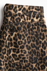 Bermuda de cinco bolsillos en denim de algodón rígido, con tiro alto, cierre y botón, y estampado animal print de leopardo.