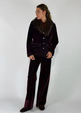 Chaqueta de denim azul oscuro con cuello de piel sintética desmontable, cierre frontal con botones metálicos y bolsillos delanteros con solapa.