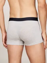 Pack de tres calzoncillos tipo trunk de algodón elástico color gris melange, con cintura elástica negra que presenta el logo y la marca Tommy Hilfiger en contraste.