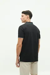 Polo de manga corta Brooksfield en color azul marino con textura. Presenta cuello clásico con cierre de botones, logo estampado en el pecho y detalles en contraste en el borde del cuello y las mangas.