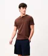 Bermuda de sarga negra de corte recto y holgado para hombre, con bolsillos cargo laterales con solapa, cintura con pasadores y cierre frontal con botón y cremallera.